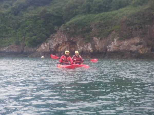 Two people kayaking along a river